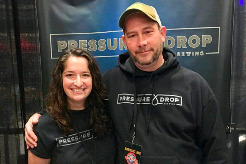 Karl Kolbe and Lexi Craine smile at the brewery